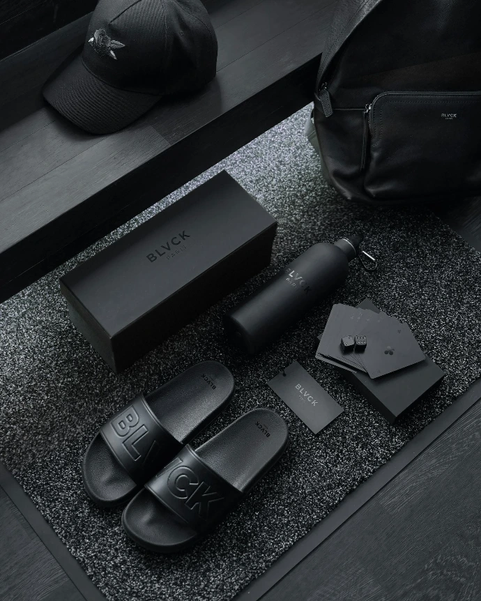 black sony remote control beside black leather bag